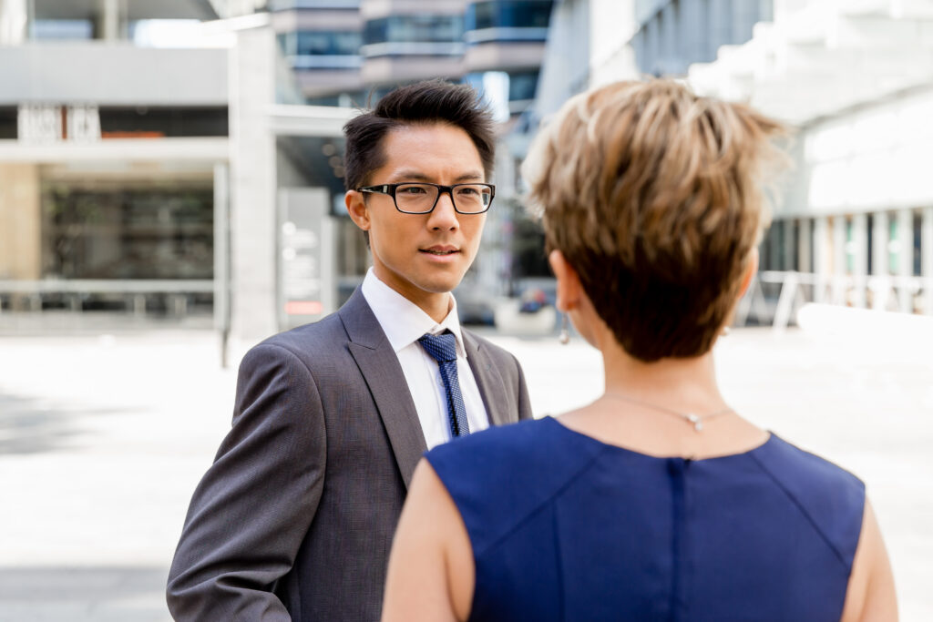 A young professional discussing with a colleague whether New Wave Executives is a scam